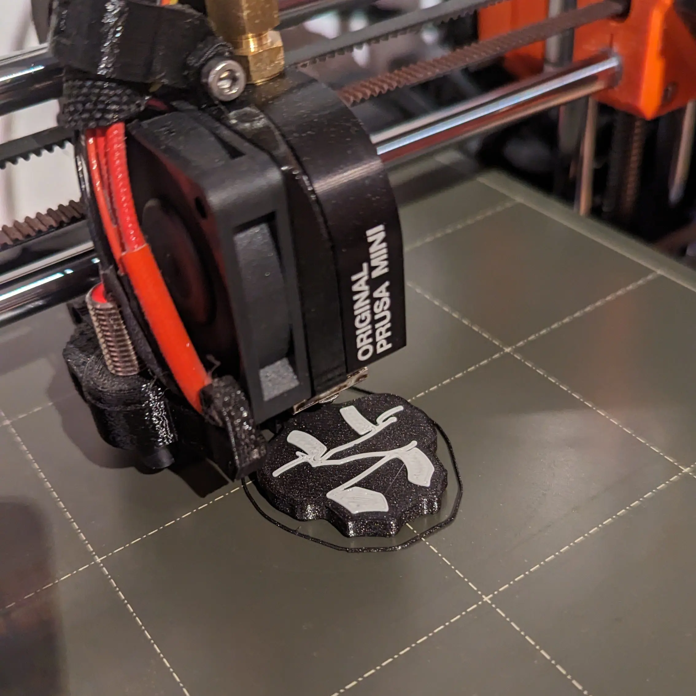 3D printer working on the 3D print "hey daddy" keychain, white on black background.